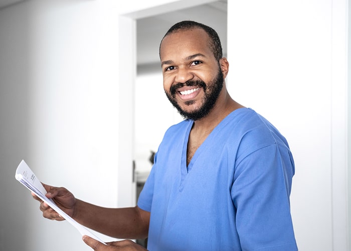 Smiling male nurse in blue scrubs